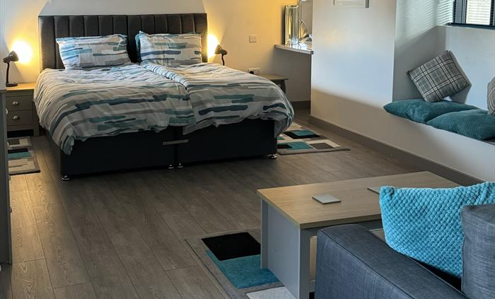 Double bed and sofas in a wellbeing retreat.